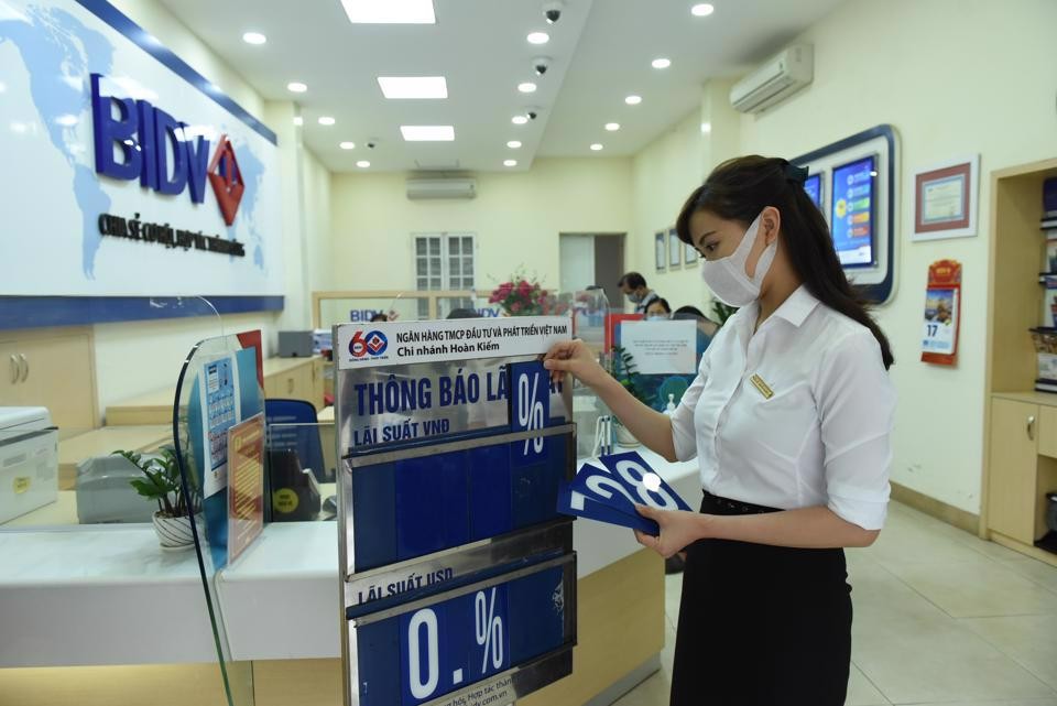 Nhân viên BIDV Hà Nội điều chỉnh lại bảng lãi suất. (Nguồn: Kinh tế & Đô thị)