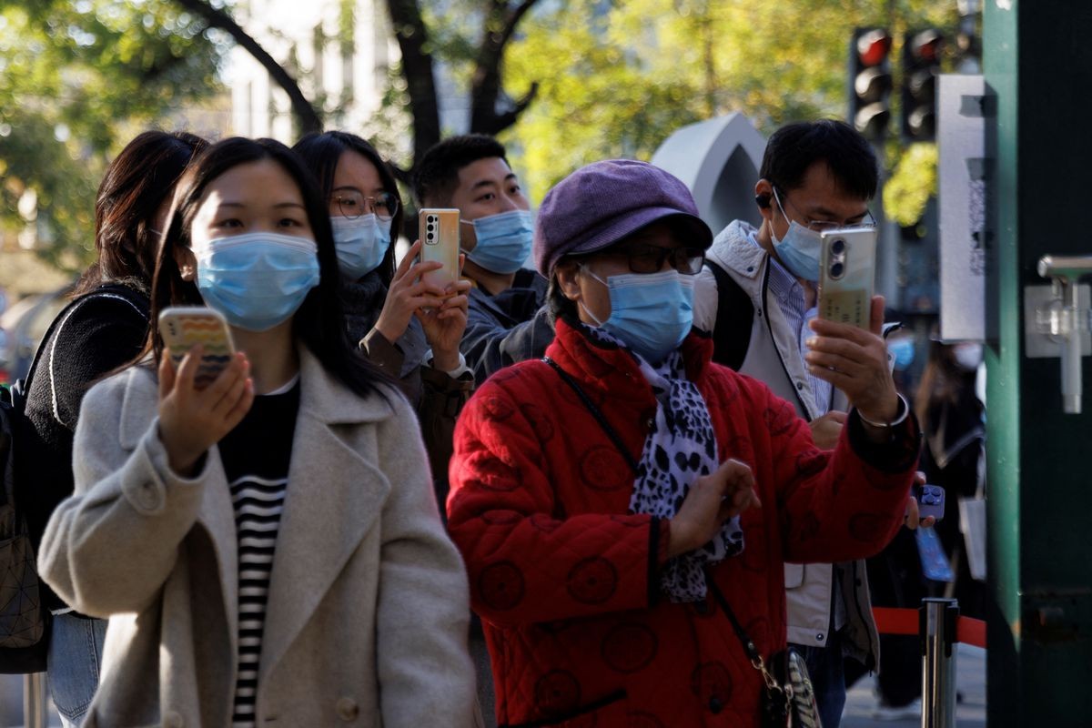 People scan their health codes before entering a fenced-off street as outbreaks of the coronavirus disease (COVID-19) continue in Beijing, China November 5, 2022. REUTERS/Thomas Peter People scan their health codes before entering a fenced-off street as outbreaks of the coronavirus disease (COVID-19) continue in Beijing, China November 5, 2022. REUTERS/Thomas Peter