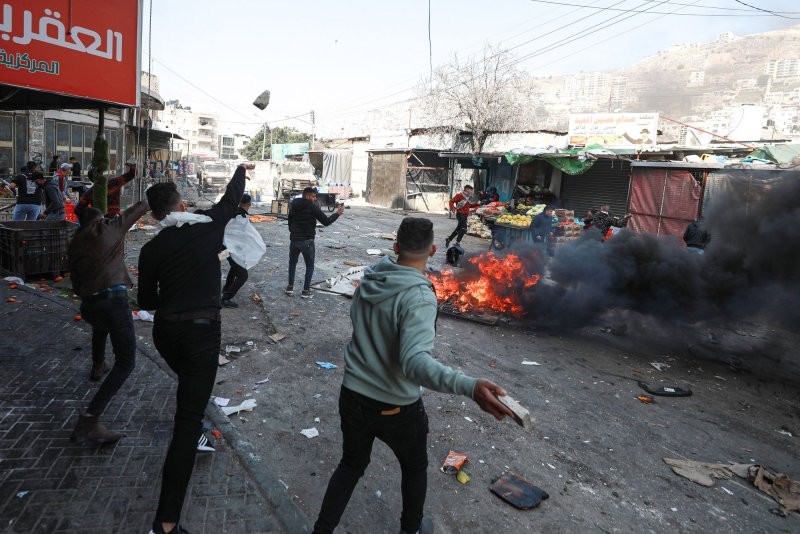 Người Palestine ném đá vào các phương tiện của quân đội Israel trong một cuộc đột kích ở thị trấn Nablus bị chiếm đóng ở Bờ Tây hôm thứ Tư Người Palestine ném đá vào các phương tiện của quân đội Israel trong một cuộc đột kích ở thị trấn Nablus bị chiếm đóng ở Bờ Tây hôm thứ Tư