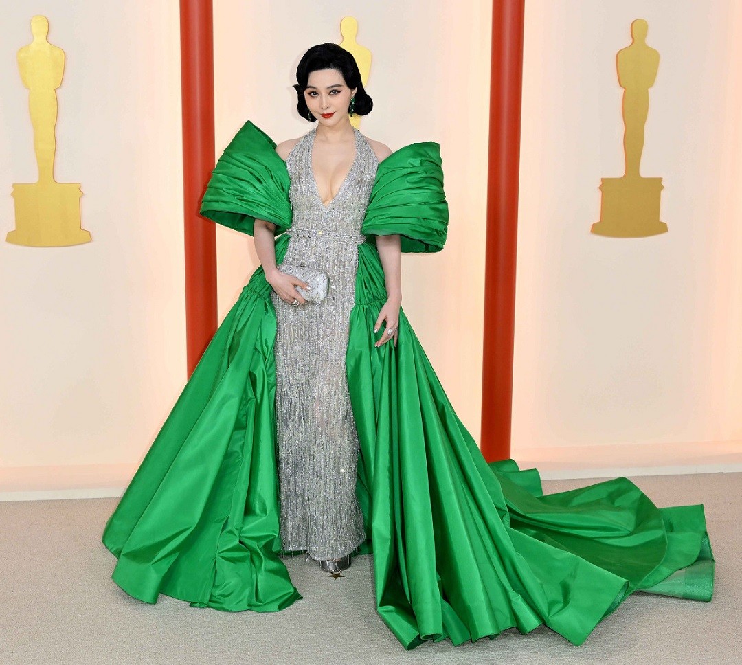 Tham dự lễ trao giải điện ảnh danh giá Oscar tại nhà hát Dolby ở Los Angeles tối 12/3, Phạm Băng Băng xuất hiện lộng lẫy trong tác phẩm Tony Ward Couture. Thiết kế ánh bạc xẻ cổ sâu quyến rũ, kết hợp phần áo choàng xanh lá chất liệu taffeta dựng phom nổi bật.