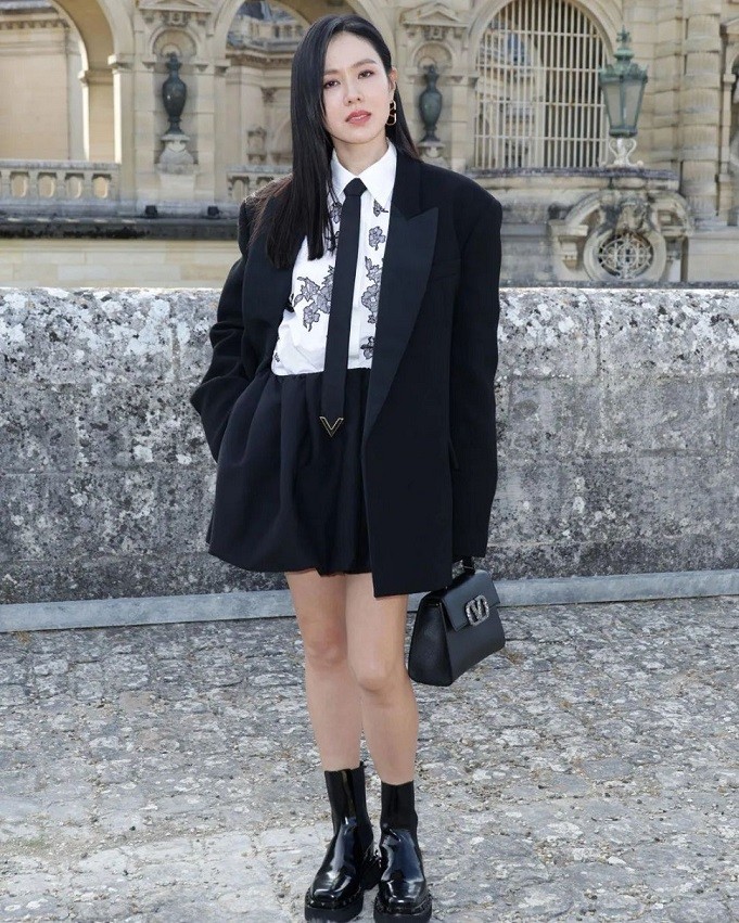 Sáng 6/7, diễn viên Son Ye Jin xuất hiện tại show thời trang cao cấp tại Pháp. Cô gây ấn tượng khi diện đồ menswear độc đáo, cá tính kết hợp blazer với sơ mi trắng họa tiết, thắt cà vạt. Cô để tóc thẳng, diện túi, boots cùng tông màu đen. Đây là set đồ thuộc bộ sưu tập Black Tie Thu Đông 2023-2024 của Valentino. 