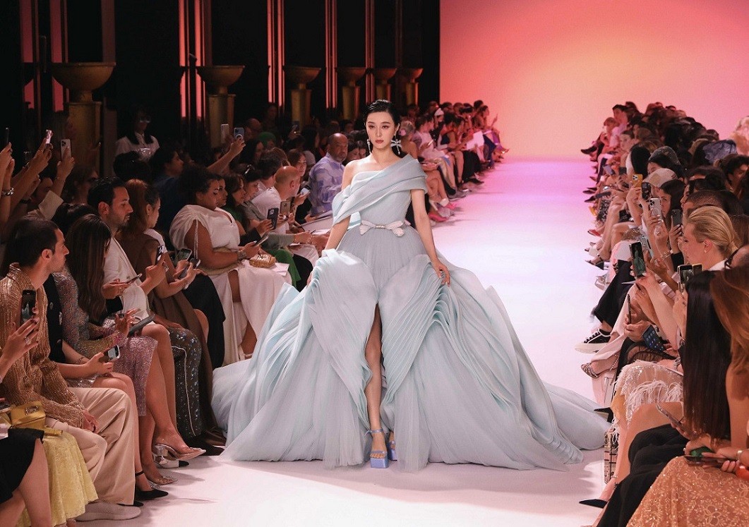 Ngay trong ngày mở màn tuần lễ thời trang cao cấp (3/7), Phạm Băng Băng trở thành tâm điểm của truyền thông khi góp mặt trên sàn diễn Georges Hobeika Haute Couture Thu Đông 2023. Mỹ nhân Trung Quốc catwalk lạnh lùng với bộ đầm lệch vai xếp tầng công phu, kết hợp sandals cao gót đồng điệu.