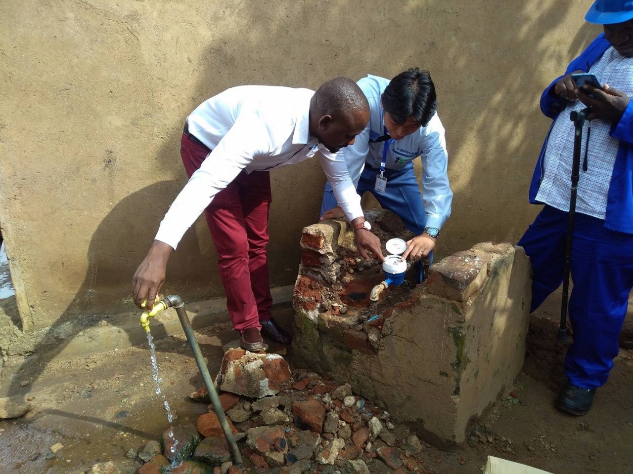 Một nhân viên của Nhà máy nước ở thành phố Yokohama cho một công nhân xem đồng hồ nước mới ở Malawi vào năm 2019. (Nguồn: Chính quyền thành phố Yokohama )