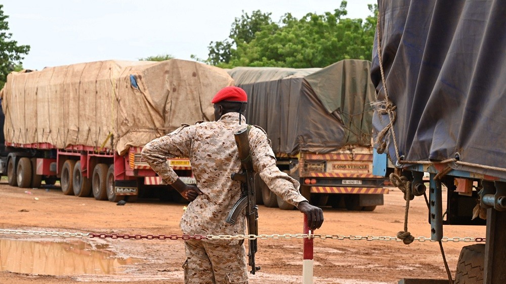 (08.22) Binh sĩ canh giữ các xe chở lương thực từ Burkina Faso tới Niger. (Nguồn: Getty Images) (08.22) Binh sĩ canh giữ các xe chở lương thực từ Burkina Faso tới Niger. (Nguồn: Getty Images)