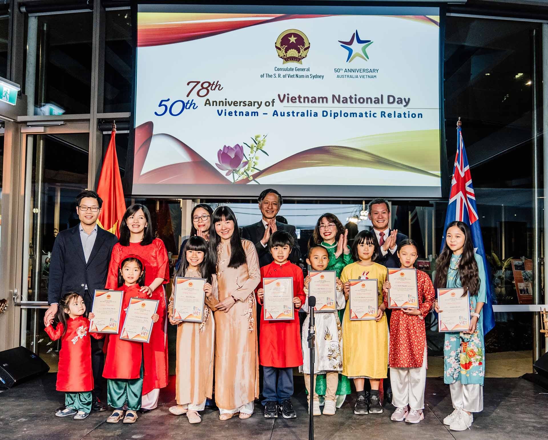 Đại sứ Nguyễn Tất Thành, Tổng lãnh sự Nguyễn Đăng Thắng và Tổng lãnh sự Nguyễn Thanh Hà và bà Nguyễn Thị Thanh Hằng (đại diện Ban giám khảo) trao giải cho một số thí sinh tham dự cuộc thi “Em siêu tiếng Việt”. Đại sứ Nguyễn Tất Thành, Tổng lãnh sự Nguyễn Đăng Thắng và Tổng lãnh sự Nguyễn Thanh Hà và bà Nguyễn Thị Thanh Hằng (đại diện Ban giám khảo) trao giải cho một số thí sinh tham dự cuộc thi “Em siêu tiếng Việt”.