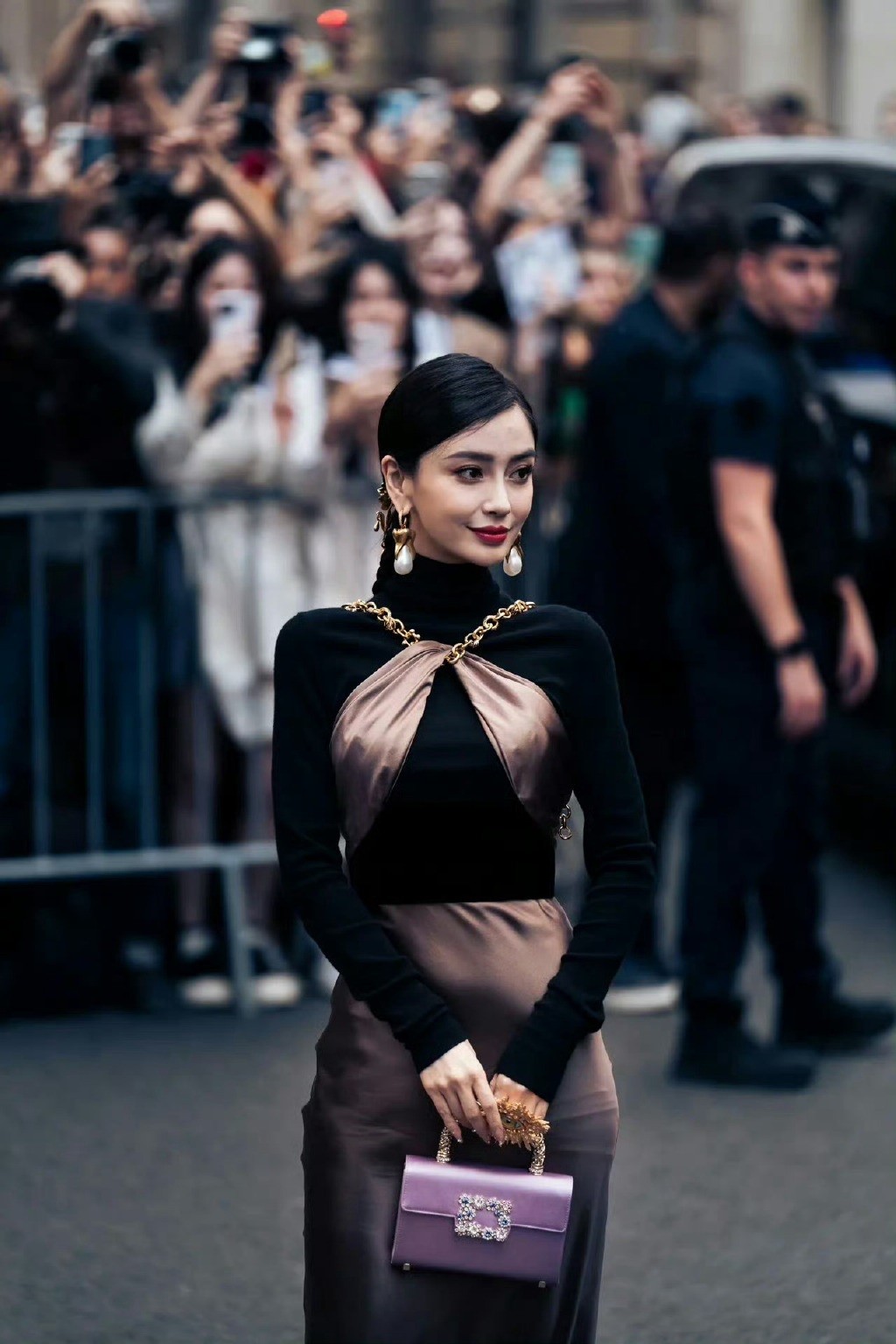 Diễn viên mặc váy của Schiaparelli, kèm phụ kiện bông tai, dây đeo tay... khổ lớn, túi xách của thương hiệu Roger Vivier. 