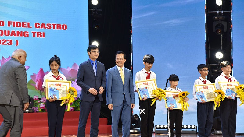 Thứ trưởng Bộ Ngoại giao Hà Kim Ngọc, Trưởng ban Tổ chức Lễ Kỷ niệm cùng lãnh đạo tỉnh Quảng Trị trao tặng giải thưởng cho các em học sinh đoạt giải trong cuộc thi sáng tác tranh kỷ niệm 50 năm Lãnh tụ Fidel thăm Việt Nam. 