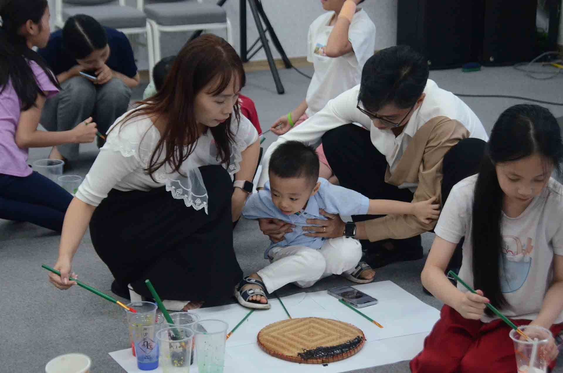 Các con cùng phụ huynh chơi trò chơi vẽ tranh lên mẹt tre. Các con cùng phụ huynh chơi trò chơi vẽ tranh lên mẹt tre.