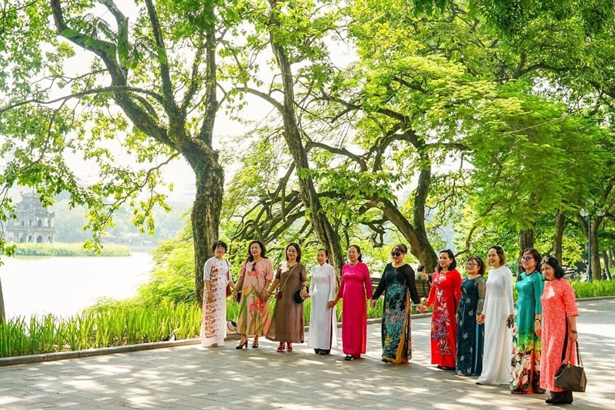 Người dân Thủ đô tranh thủ ghi lại hình ảnh Thu và áo dài Hà Nội. (Nguồn: TTXVN)