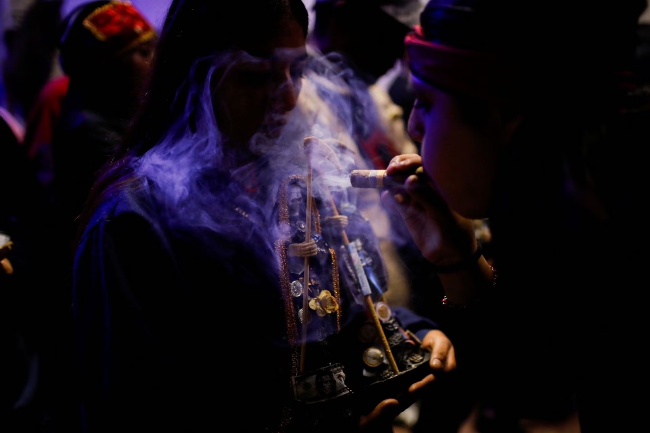 Một người phụ nữ thổi khói vào bức tượng La Santa Muerte (Thánh chết) trong thánh lễ thuộc lễ kỷ niệm Ngày của người chết ở Nezahualcoyotl, Bang Mexico, Mexico ngày 2 tháng 11.