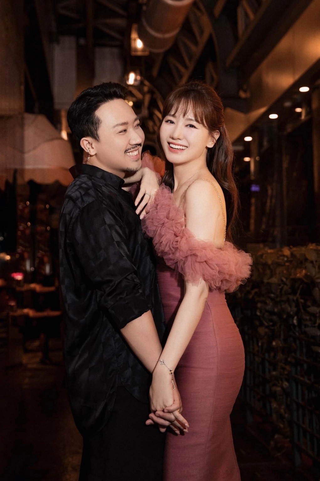 Trấn Thành và Hari Won tay trong tay đón Giáng sinh với trang phục chỉn chu. Sóng đôi bên bà xã với đầm dáng gợi cảm, Trấn Thành chọn sắc đen giúp vợ thêm nổi bật.