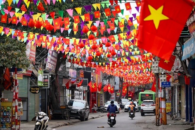 Cờ, hoa đỏ rợp cả con phố dịp Tết đến, Xuân về. (Ảnh: Minh Hiếu/Vietnam+) Cờ, hoa đỏ rợp cả con phố dịp Tết đến, Xuân về. (Ảnh: Minh Hiếu/Vietnam+)