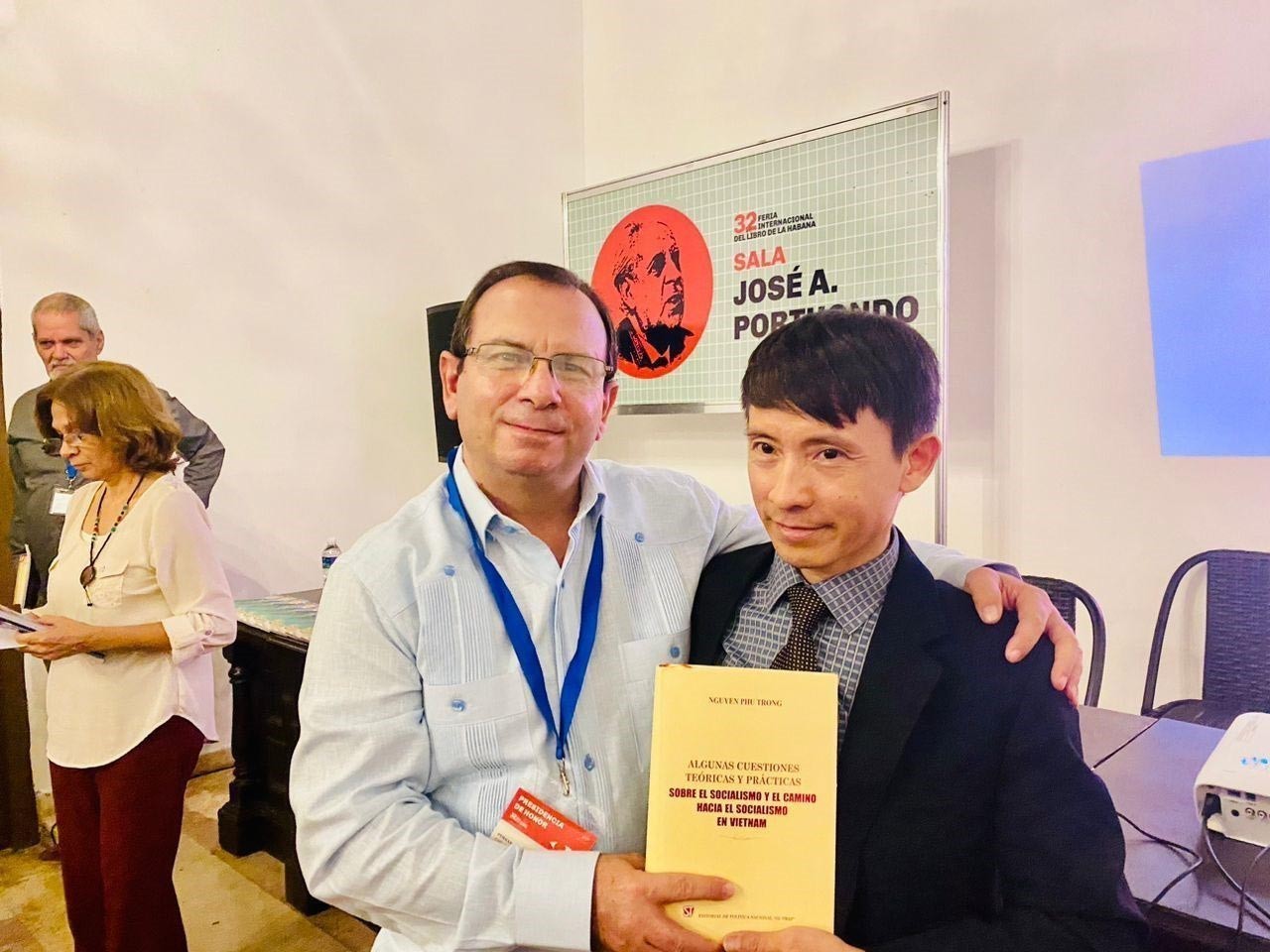 Phó Giám đốc, Phó Tổng Biên tập Nhà Xuất bản Chính trị Quốc gia – Sự thật, Võ Văn Bé tặng Chủ tịch Viện Cuba Hữu nghị với các Dân tộc, Anh hùng Cộng hòa Cuba Fernando González Llort cuốn sách của Tổng Bí thư Nguyễn Phú Trọng. Ảnh: Mai Phương - Pv TTXVN tại Cuba