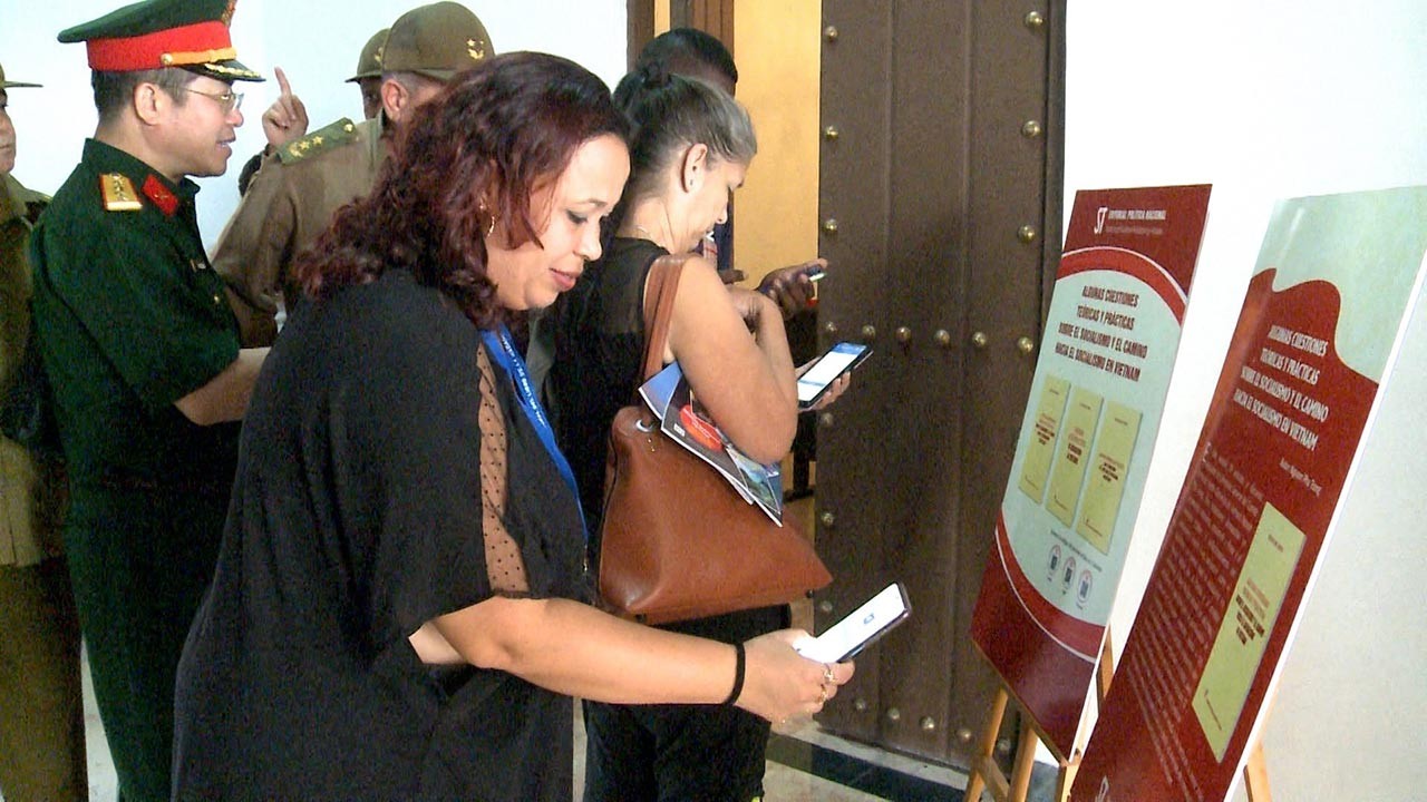 Độc giả Cuba quét mã QR để tải các phiên bản tiếng Tây Ban Nha, tiếng Anh và tiếng Pháp của cuốn sách “Một số vấn đề lý luận và thực tiễn về chủ nghĩa xã hội và con đường xây dựng chủ nghĩa xã hội ở Việt Nam” của Tổng Bí thư Nguyễn Phú Trọng. Ảnh: Mai Phư