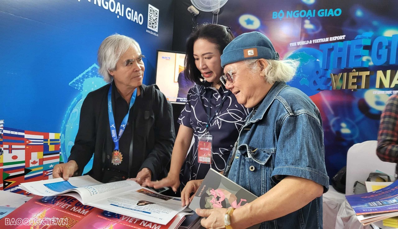Phó Tổng Biên tập Nguyễn Thị Minh Nguyệt đang trao đổi về sự phát triển của Báo với các vị khách đặc biệt, phóng viên ảnh của hãng AP Mỹ Nick Út nổi tiếng và  nhà báo -phóng viên ảnh  Giản Thanh Sơn  tại gian hàng. (Ảnh: Minh Hòa)