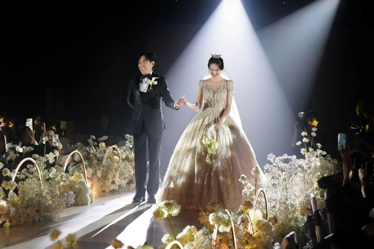 Chiếc đầm được Quỳnh Anh diện trong khoảnh khắc nắm tay Anh Đức bước lên lễ đường có kiểu dáng xòe bồng mang cảm hứng công chúa cổ tích. NTK Choi Jae Hoon sử dụng chất liệu ren thêu tay thủ công hàng chục giờ, xếp chồng nhiều lớp để tạo độ phồng nhưng vẫn toát lên sự nhẹ nhàng. Chiếc đầm được Quỳnh Anh diện trong khoảnh khắc nắm tay Anh Đức bước lên lễ đường có kiểu dáng xòe bồng mang cảm hứng công chúa cổ tích. NTK Choi Jae Hoon sử dụng chất liệu ren thêu tay thủ công hàng chục giờ, xếp chồng nhiều lớp để tạo độ phồng nhưng vẫn toát lên sự nhẹ nhàng.