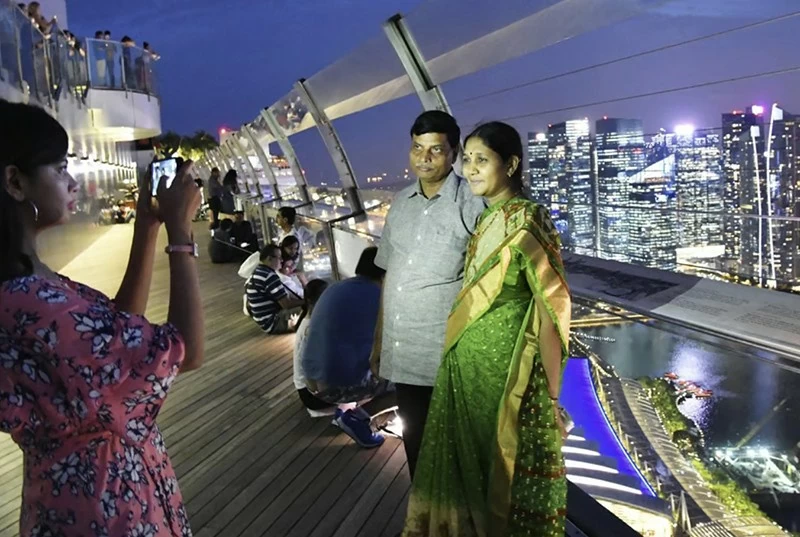 Khách du lịch tạo dáng chụp ảnh trên đài quan sát của Marina Bay Sands ở Singapore. Ảnh: Kyodo News Stills qua Getty Images Khách du lịch tạo dáng chụp ảnh trên đài quan sát của Marina Bay Sands ở Singapore. Ảnh: Kyodo News Stills qua Getty Images