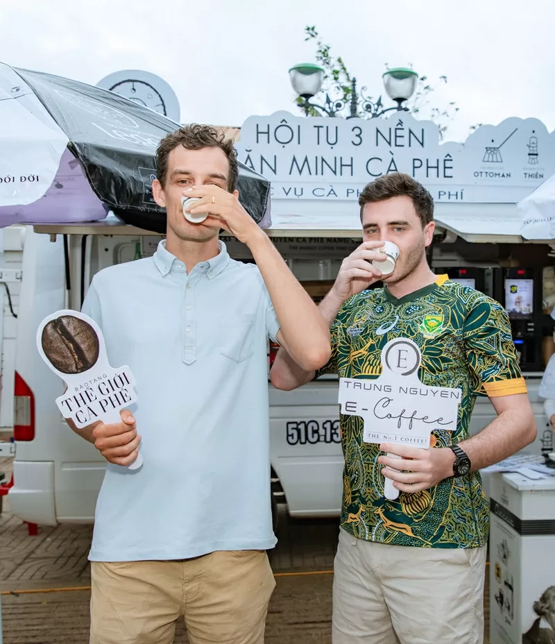 Hai du khách quốc tế hào hứng thưởng thức những ly cà phê năng lượng tuyệt hảo được Trung Nguyên Legend phục vụ trong Ngày hội cà phê miễn phí Hai du khách quốc tế hào hứng thưởng thức những ly cà phê năng lượng tuyệt hảo được Trung Nguyên Legend phục vụ trong Ngày hội cà phê miễn phí