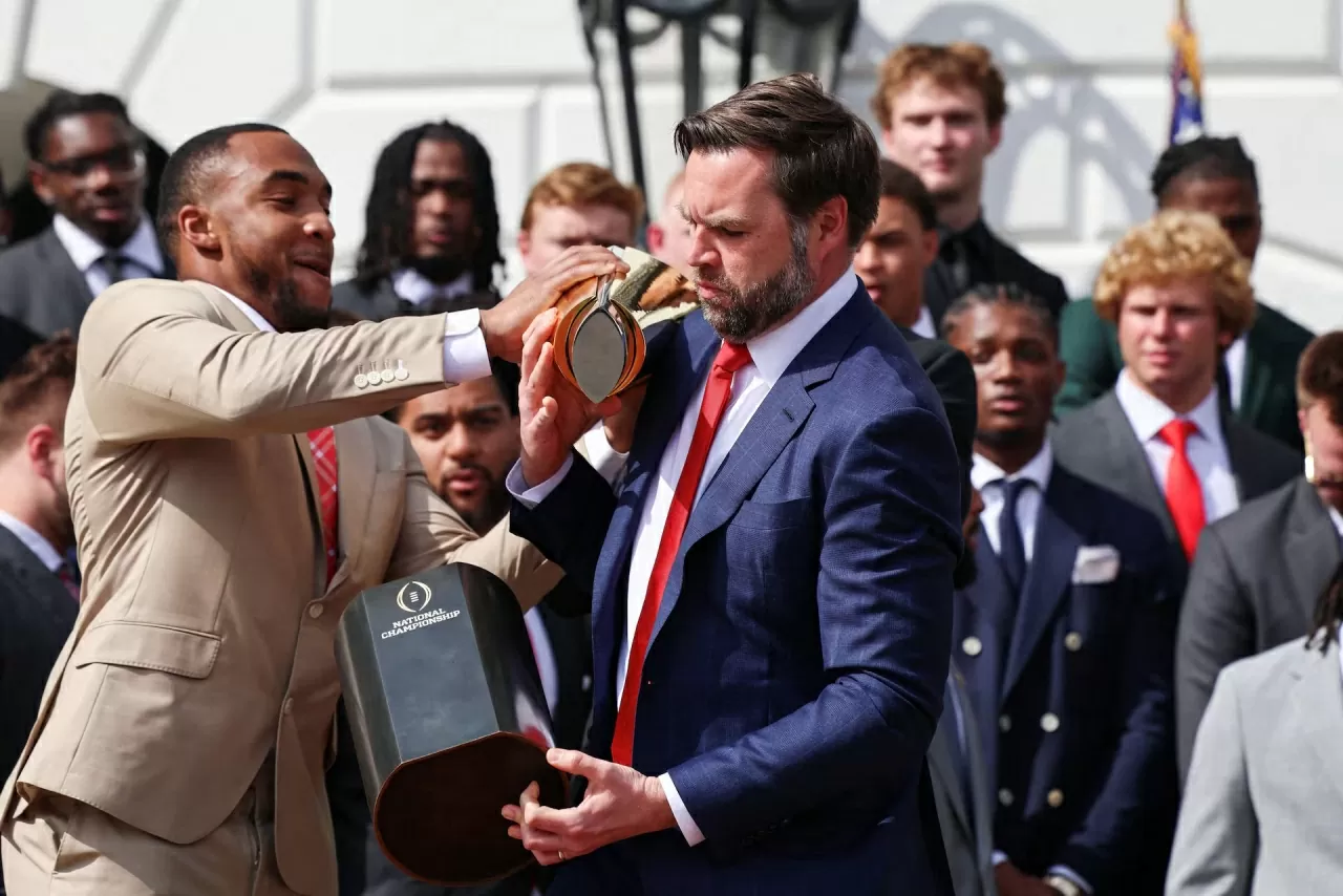 Phó Tổng thống Mỹ JD Vance làm rơi chiếc cúp khi ông và Tổng thống Donald Trump tiếp đón đội vô địch quốc gia bóng đá đại học 2025 của Đại học bang Ohio tại Nhà Trắng vào ngày 14/4. (Nguồn: Reuters)