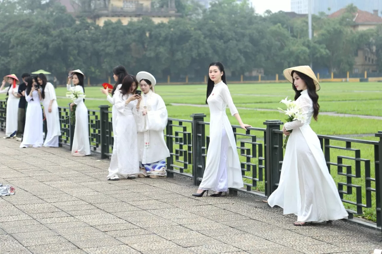 Chỉ còn khoảng hơn tuần nữa là đến dịp kỷ niệm 50 năm Ngày Giải phóng miền Nam, thống nhất đất nước (30/4/1975 - 30/4/2025), nhưng không khí tại Quảng trường Ba Đình (Hà Nội) đã vô cùng nhộn nhịp, thu hút nhiều người dân và du khách mặc những bộ trang phục áo dài...đến chụp ảnh cùng lá cờ Tổ quốc. (Ảnh: Thành Long)