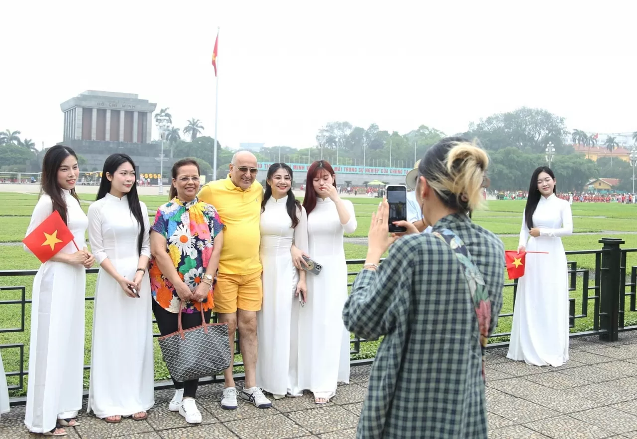 Ngay cả những du khách nước ngoài cũng không thể giấu nổi sự thích thú khi được chiêm ngưỡng vẻ đẹp của những thiếu nữ Việt Nam trong tà áo dài đặc trưng. (Ảnh: Thành Long)