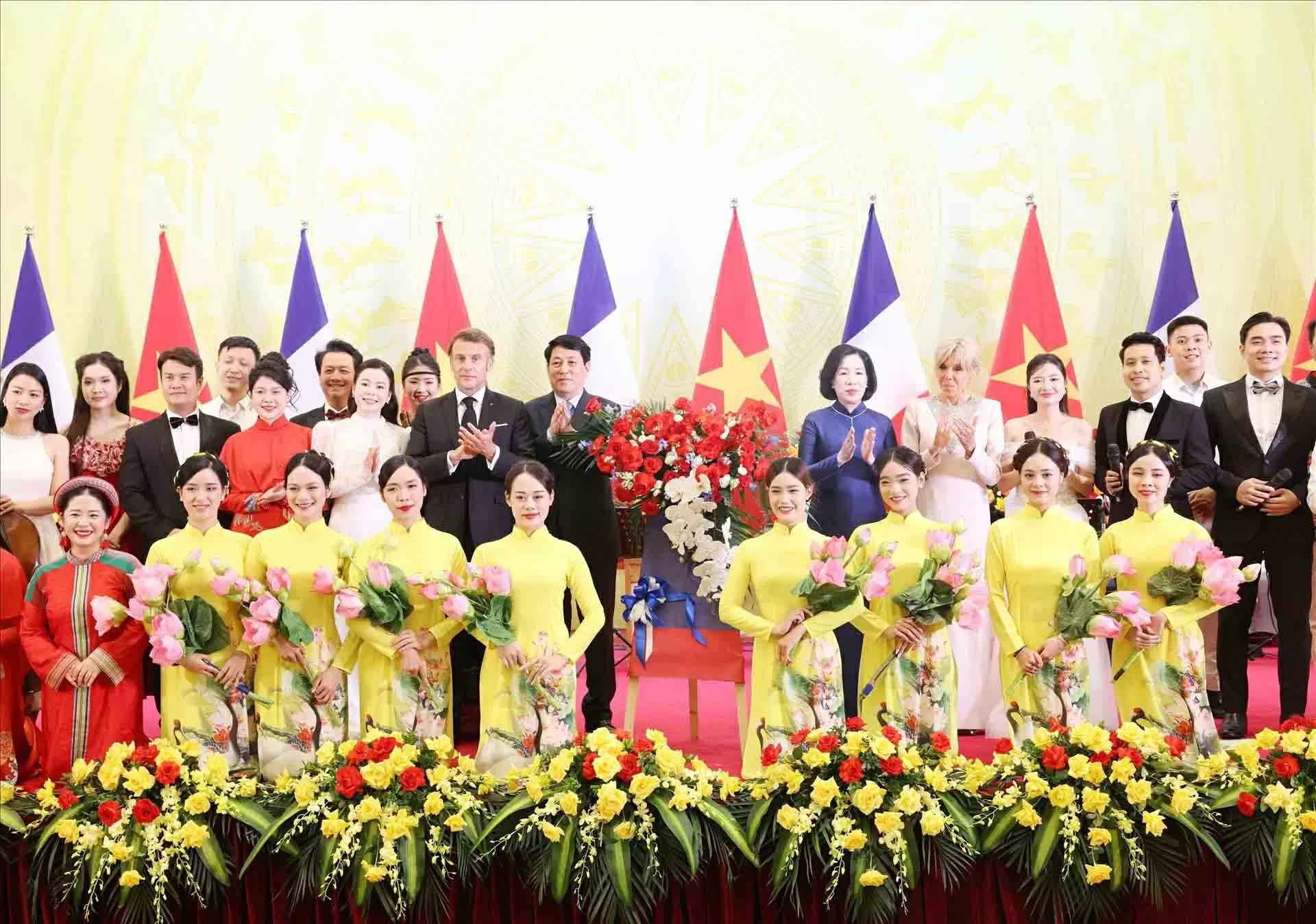 Chủ tịch nước Lương Cường và Phu nhân cùng Tổng thống Pháp Emmanuel Macron và Phu nhân với các nghệ sĩ biểu diễn tại tiệc chiêu đãi. (Nguồn: TTXVN)