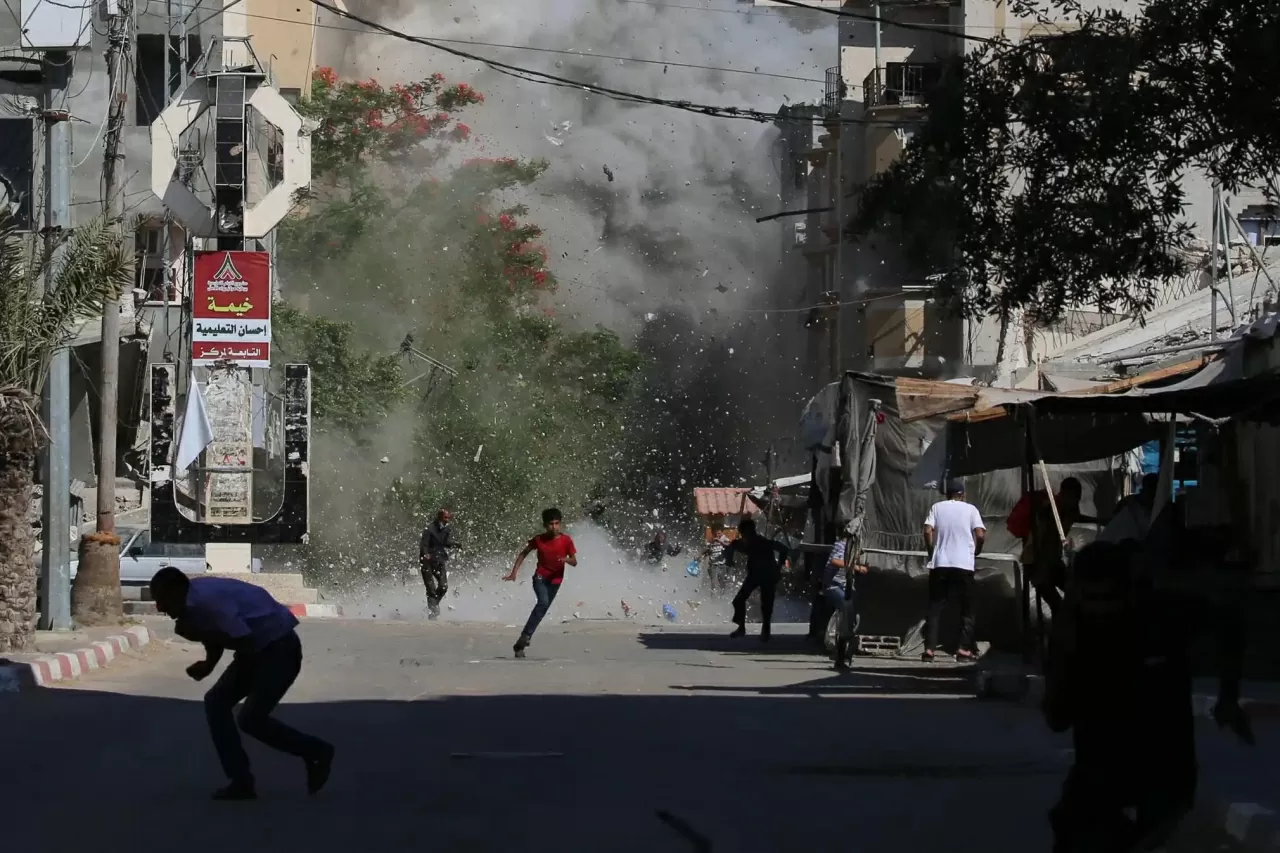 Người Palestine chạy tìm nơi ẩn nấp khi các mảnh vỡ bay tứ tung sau một cuộc không kích của Israel nhằm vào trại tị nạn Bureij ở trung tâm Dải Gaza. Ít nhất tám người Palestine đã thiệt mạng và hàng chục người khác bị thương hôm Chủ nhật trong các vụ nổ súng gần các điểm phân phát lương thực tại Gaza. Cư dân địa phương cho biết các cuộc tấn công của Israel đã leo thang, song song với xung đột mới với Iran. (Nguồn: Getty Images) Người Palestine chạy tìm nơi ẩn nấp khi các mảnh vỡ bay tứ tung sau một cuộc không kích của Israel nhằm vào trại tị nạn Bureij ở trung tâm Dải Gaza. Ít nhất tám người Palestine đã thiệt mạng và hàng chục người khác bị thương hôm Chủ nhật trong các vụ nổ súng gần các điểm phân phát lương thực tại Gaza. Cư dân địa phương cho biết các cuộc tấn công của Israel đã leo thang, song song với xung đột mới với Iran. (Nguồn: Getty Images)