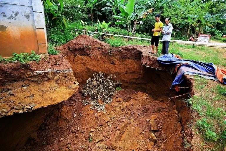 Hố sụt lún làm lộ toàn bộ phần móng và khoét sâu vào bên trong móng nhà kiên cố khoảng 1,5m. (Nguồn: TTXVN) Hố sụt lún làm lộ toàn bộ phần móng và khoét sâu vào bên trong móng nhà kiên cố khoảng 1,5m. (Nguồn: TTXVN)