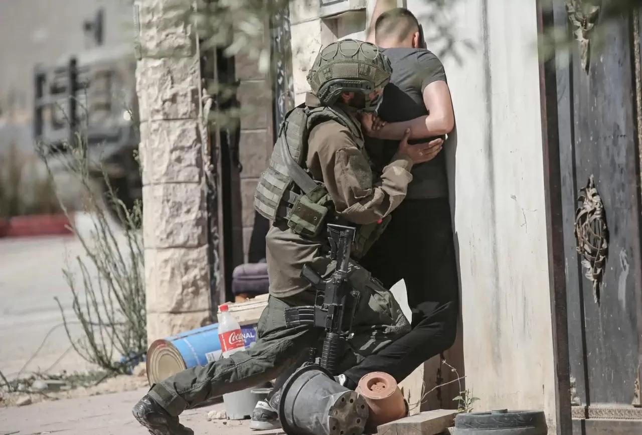 Một binh sĩ Israel khám xét một thanh niên Palestine khi anh cố gắng vượt qua vào trại tị nạn Tulkarm ở Bờ Tây, trong bối cảnh các chiến dịch quân sự của Israel tiếp tục diễn ra tại khu vực nhằm chuẩn bị cho kế hoạch phá dỡ một ngôi nhà. Các vụ bạo lực do người định cư gây ra ở Bờ Tây đã gia tăng mạnh kể từ sau cuộc tấn công của Hamas vào ngày 7 tháng 10 năm 2023 và cuộc chiến tiếp theo ở Gaza. Sự trỗi dậy của các bộ trưởng cực hữu như Bezalel Smotrich và Itamar Ben-Gvir đã tạo ra “lá chắn chính Một binh sĩ Israel khám xét một thanh niên Palestine khi anh cố gắng vượt qua vào trại tị nạn Tulkarm ở Bờ Tây, trong bối cảnh các chiến dịch quân sự của Israel tiếp tục diễn ra tại khu vực nhằm chuẩn bị cho kế hoạch phá dỡ một ngôi nhà. Các vụ bạo lực do