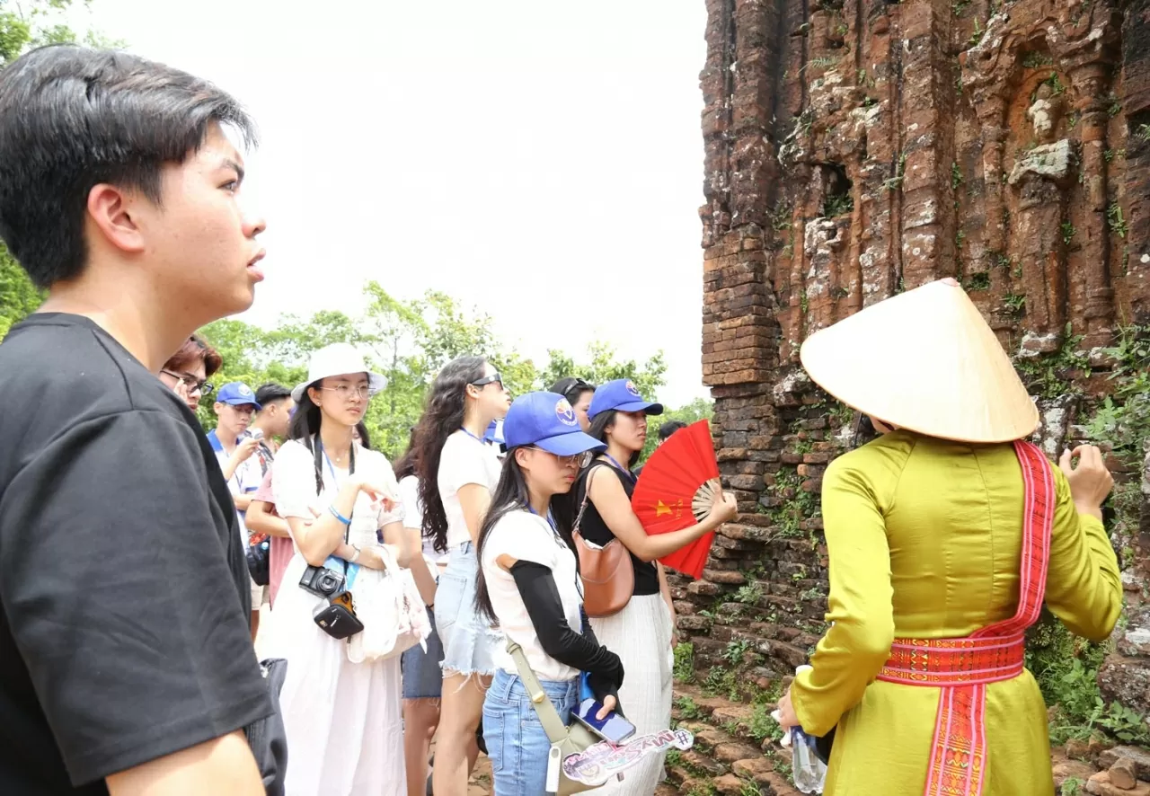 Nguyễn Bá Bảo, kiều bào từ Pháp (áo đen) nghe hướng dẫn viên giới thiệu về Thánh địa Mỹ Sơn. (Ảnh: Thành Long) Nguyễn Bá Bảo, kiều bào từ Pháp (áo đen) nghe hướng dẫn viên giới thiệu về Thánh địa Mỹ Sơn. (Ảnh: Thành Long)