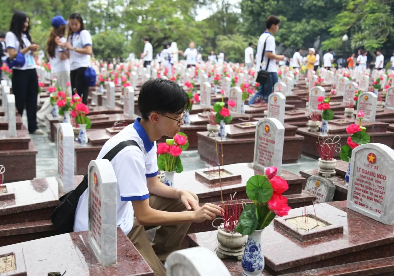 Đoàn thanh niên, sinh viên kiều bào dâng hương lên phần mộ của các liệt sĩ. (Ảnh: Thành Long)