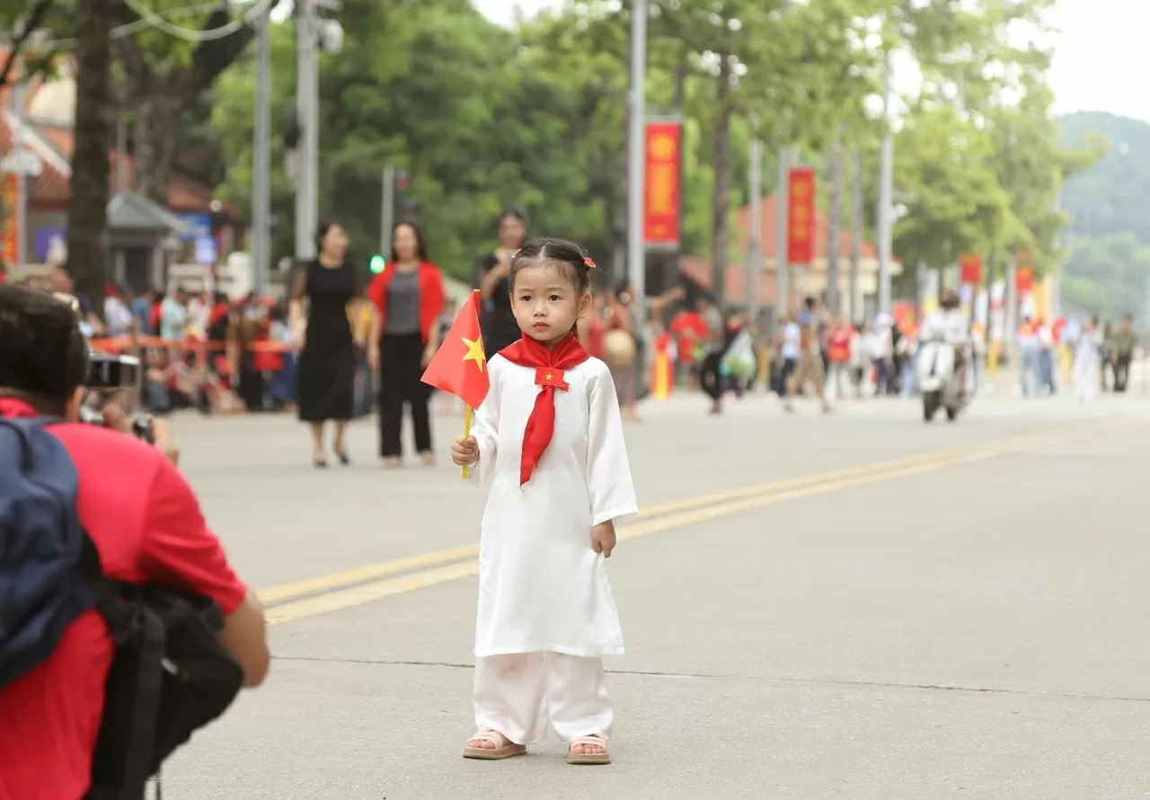 Cờ đỏ sao vang, khăn và áo dài rạng rỡ khắp các tuyến phố Thủ đô. (Ảnh: Thành Long) Cờ đỏ sao vang, khăn và áo dài rạng rỡ khắp các tuyến phố Thủ đô. (Ảnh: Thành Long)