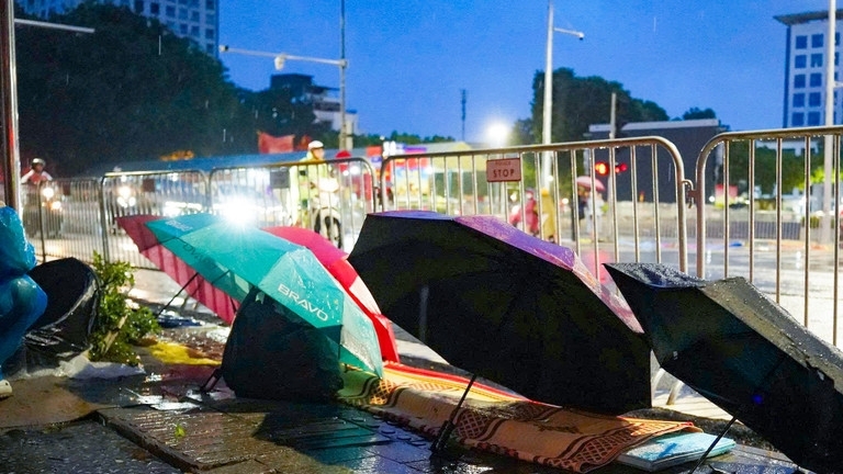 Người dân trải chiếu, đội mưa từ đêm đến sáng sớm để giữ chỗ xem sơ duyệt diễu binh, diễu hành Đại lễ A80