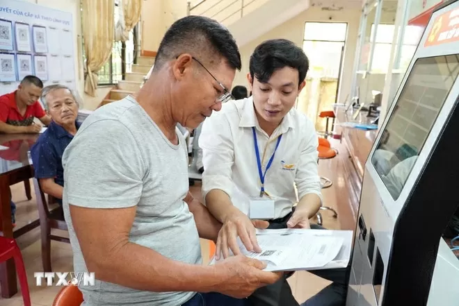 Cán bộ hướng dẫn người dân thực hiện thủ tục hành chính. (Ảnh: Đinh Hương/TTXVN) Cán bộ hướng dẫn người dân thực hiện thủ tục hành chính. (Ảnh: Đinh Hương/TTXVN)