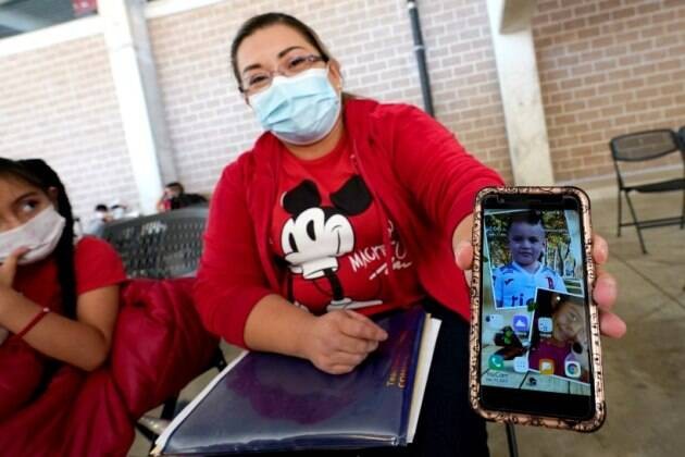 Ana Icela Cuellar, một người di cư từ El Salvador “khoe” điện thoại di động với hình ảnh của con gái Genesis, 8 tuổi và con trai Andy Nathanael, 4 tuổi trong quá trình chờ nhóm nhân đạo Team Brownsville hỗ trợ giải phóng người di cư đang bị Cơ quan Hải qu