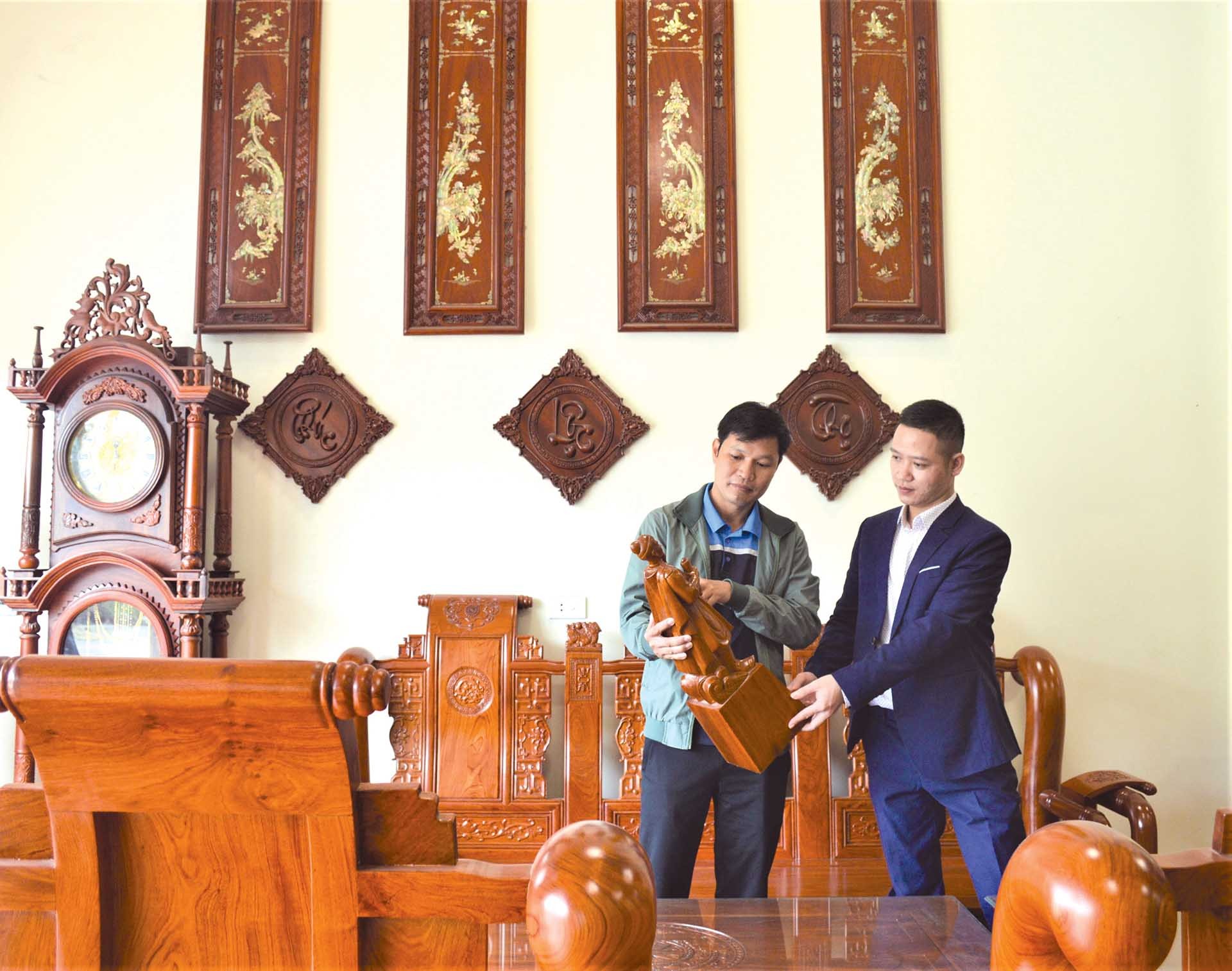 Nghệ nhân Phạm Quốc Hùng và cán bộ thị trường Nguyễn Mạnh Cường đang trao đổi về sản phẩm mà gần đây người tiêu dùng đang quan tâm. (Ảnh: MH)