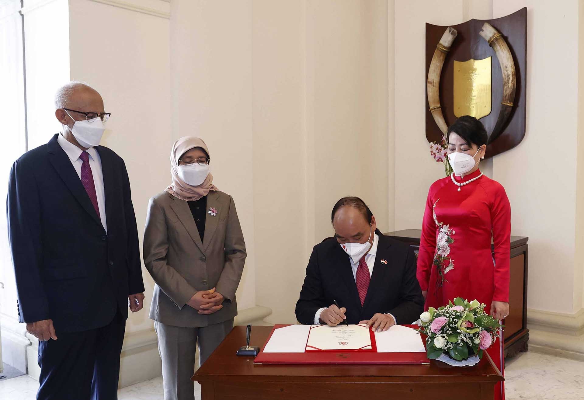 Chủ tịch nước Nguyễn Xuân Phúc ghi vào Sổ vàng lưu niệm tại Phủ Tổng thống Singapore. (Nguồn: TTXVN)