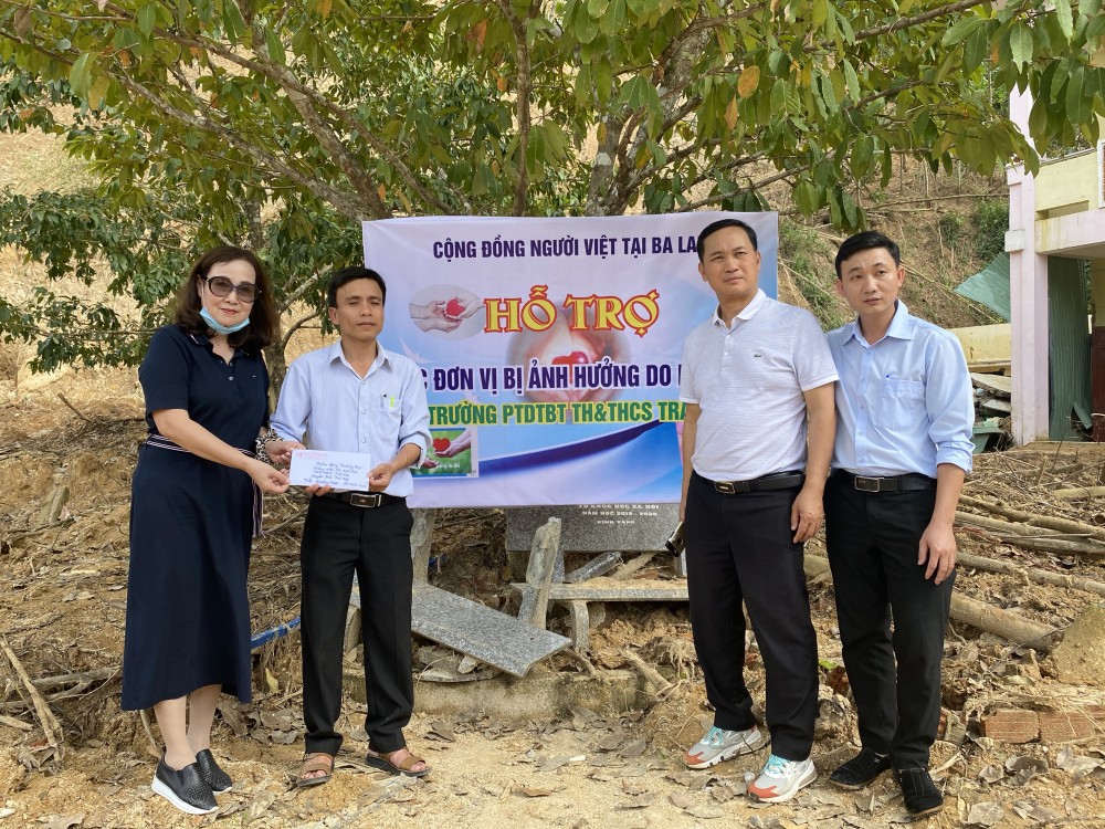 Chị Triều đại diện cho Hội người Việt tại Ba Lan tặng quà cho bà con ở miền Trung bị ảnh hưởng bởi lũ lụt.