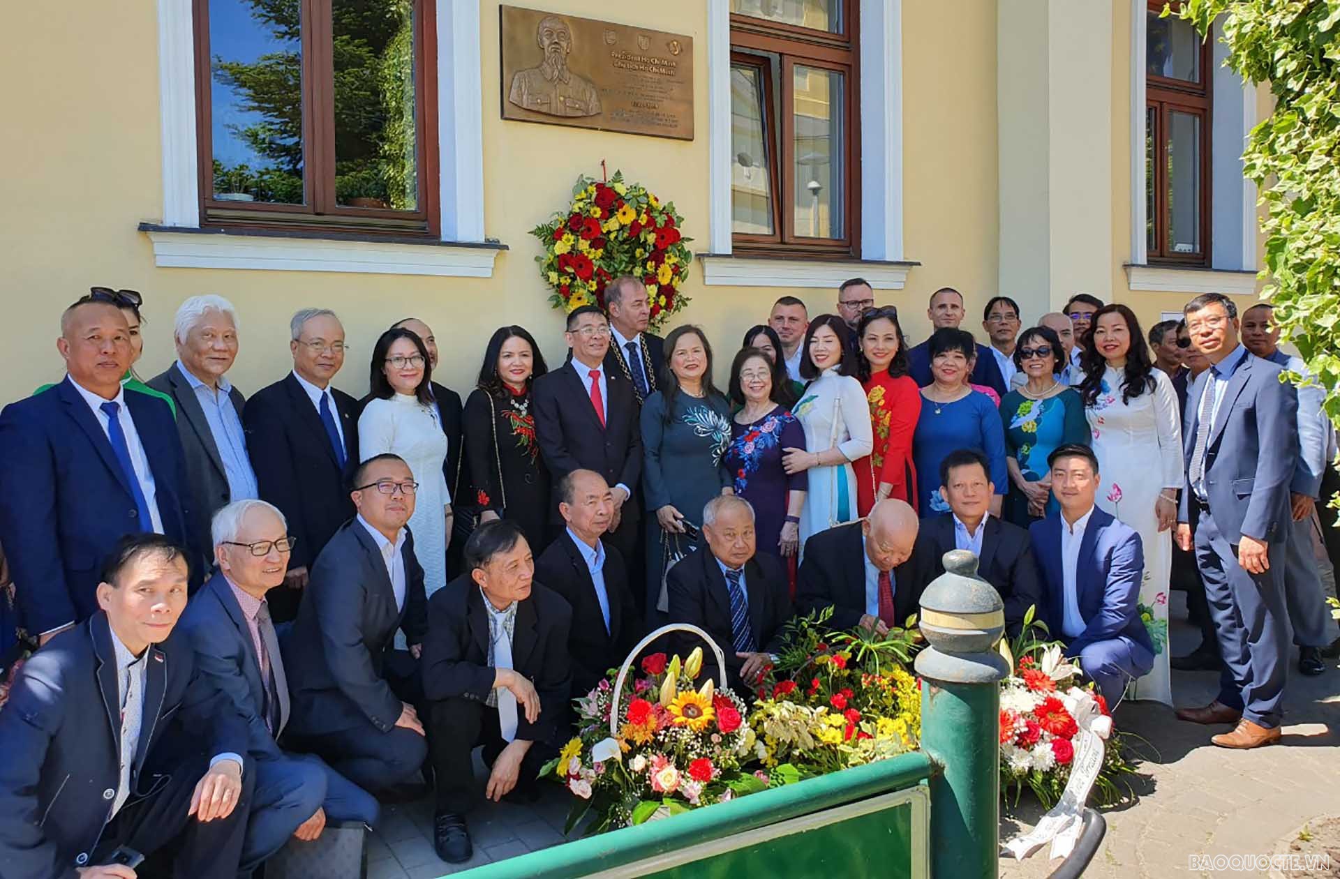 Các đại biểu chụp ảnh dưới biển đồng lưu niệm đặt tại nơi Bác Hồ tới thăm thị trấn Horne Saliby.