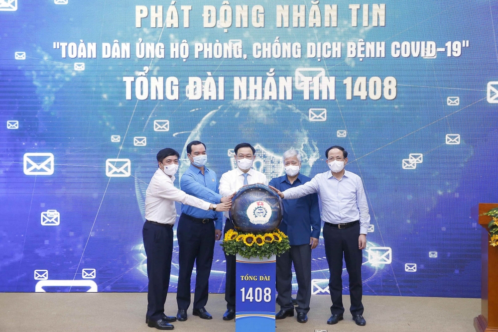 Chủ tịch Quốc hội Vương Đình Huệ và các đại biểu thực hiện nghi thức phát động nhắn tin “Toàn dân ủng hộ phòng, chống dịch bệnh COVID-19”. Ảnh: Doãn Tấn - TTXVN