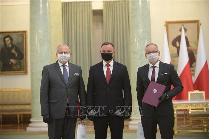 Tổng thống Ba Lan Andrzej Duda (giữa) tại lễ bổ nhiệm tân Ngoại trưởng Zbigniew Rau (trái) và tân Bộ trưởng Y tế Adam Niedzielski ở Vacsava, Ba Lan, ngày 26/8/2020. Ảnh: PAP/TTXVN dien-mung-bo-truong-ngoai-giao-nuoc-cong-hoa-ba-lan