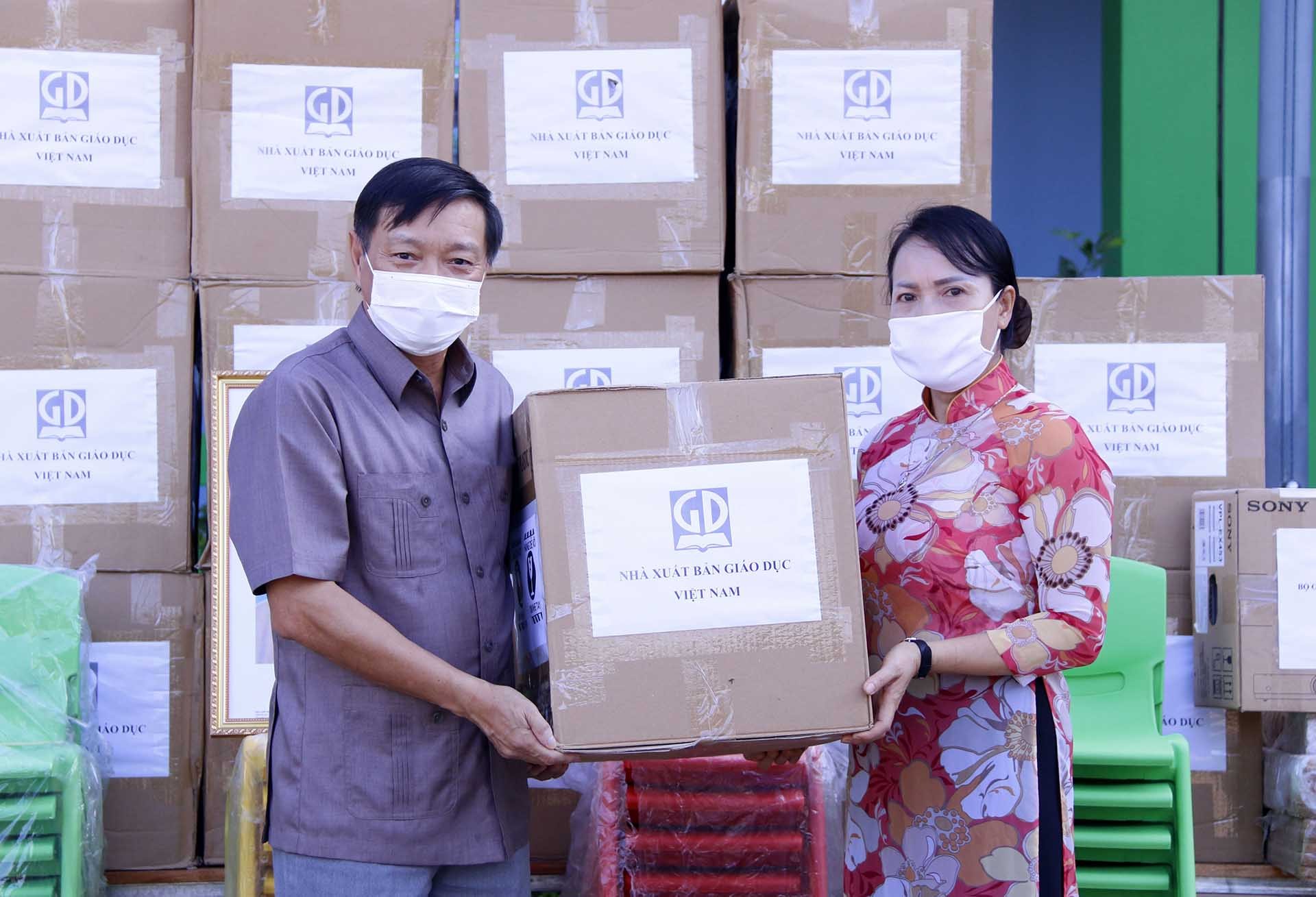 Đại sứ Nguyễn Bá Hùng đang trao tượng trưng số quà của Bộ Giáo dục cho bà Sivanheuang Phengkhammay, Hiệu trưởng Trường song ngữ Lào – Việt Nam Nguyễn Du. (Nguồn: TTXVN)