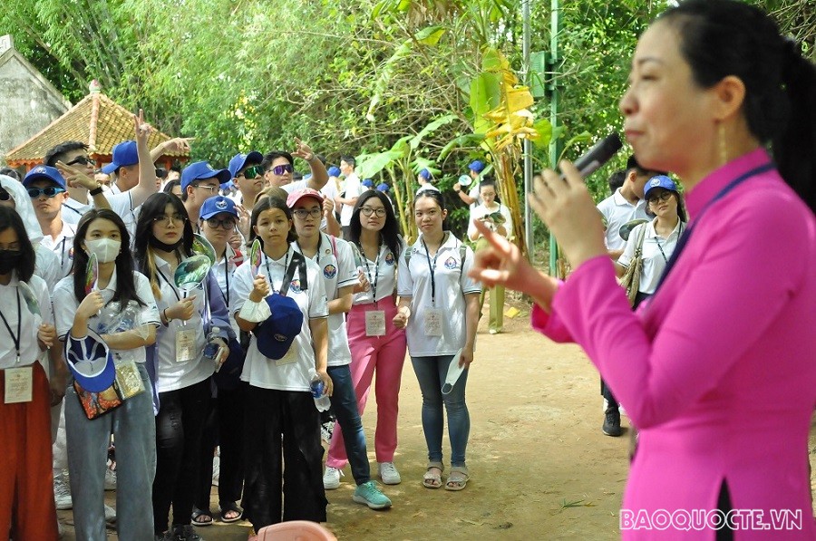 (07.23) Các thanh niên, kiều bảo trẻ lắng nghe hướng dẫn viên chia sẻ những câu chuyện về gia đình của Bác, từ đỏ hiểu thêm về hoàn cảnh, những động lực, song cũng là trăn trở của Người trong hành trình cứu nước. (Ảnh: Minh Quân)