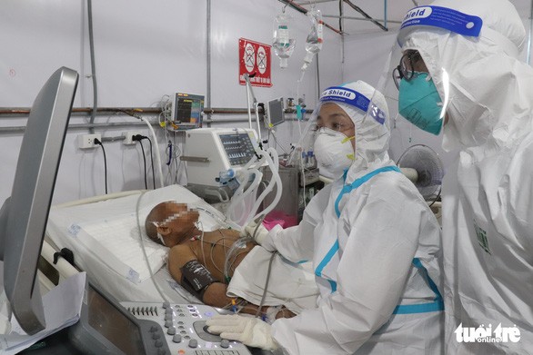 Các bác sĩ thăm khám một cụ ông nhiễm COVID-19 nguy kịch kèm nhiều bệnh nền - Ảnh: XUÂN MAI