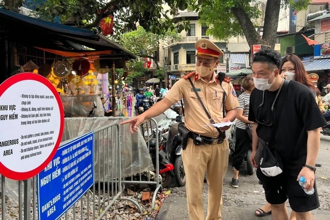 Lực lượng CSGT phát tờ rơi, giải thích cho du khách nước ngoài hiểu về việc tuyên truyền, tránh mất an toàn giao thông tại khu vực Tuyên truyền về an toàn giao thông, CSGT phát tờ rơi song ngữ trên ‘phố đường tàu’