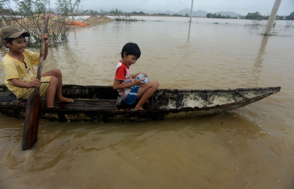 Bị lũ cô lập, trẻ em chèo xuồng đi xin nước sạch