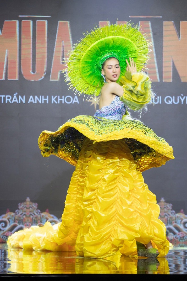 Thí sinh Bùi Quỳnh Hoa trình diễn trang phục 'Mùa vàng' của NTK Trần Anh Khoa. Người đẹp thuộc số ít thí sinh nhận tràng pháo tay lớn từ người xem khi xuất hiện. Dù thiết kế cồng kềnh, cô không gặp khó khăn khi di chuyển nhờ kinh nghiệm nhiều năm làm người mẫu.