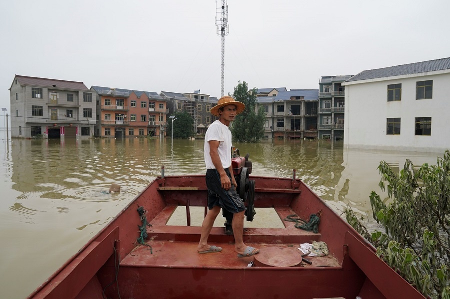 Hơn 41.700 người sống tại tỉnh Giang Tây đang chống chọi với lũ. Trong ảnh là ngư dân Zou Daoman, 52 tuổi, dùng thuyền đánh cá để hỗ trợ người dân sơ tán đến nơi an toàn. 5828 6