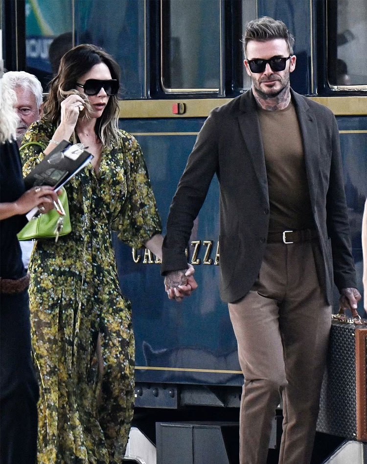 Trước đó, vợ chồng Becks cùng người nhà đi tàu hỏa từ Pháp sang Italy. Cựu tiền vệ MU nắm tay vợ ở ga tàu.