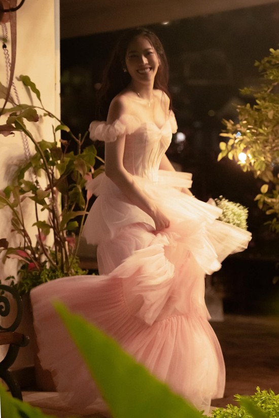 Nam Em sử dụng đầm trễ vai, xếp tầng để tôn nét duyên dáng.